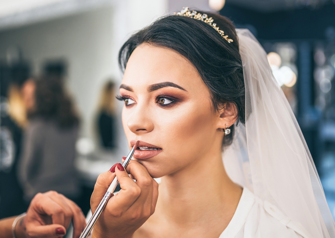 Braut mit natürlichem Braut-Make-up und Blumenstrauß
